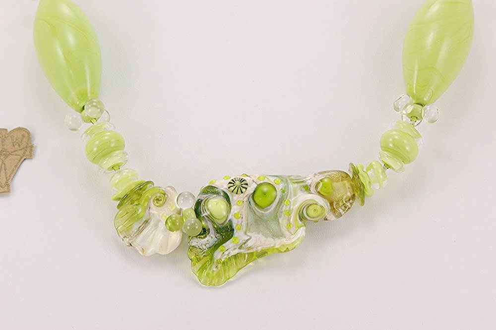 necklace made with lime green and ivory colored glass beads flanked by clear quartz round beads