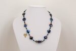 necklace with metallic blue and raspberry glass beads.