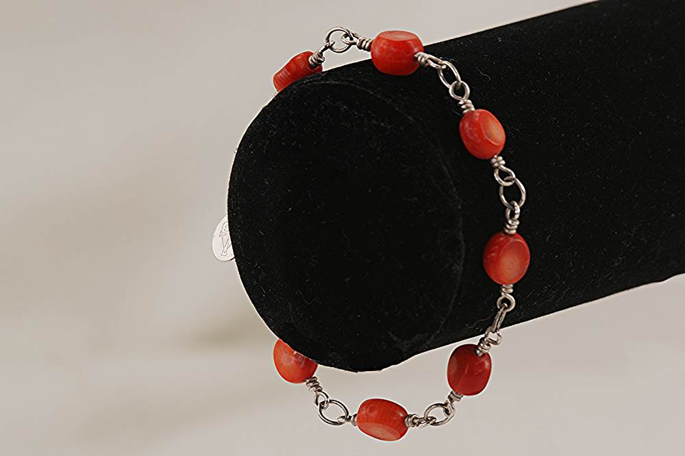 Bracelet handmade with persimmon colored, bamboo coral beads on sterling silver wire links.