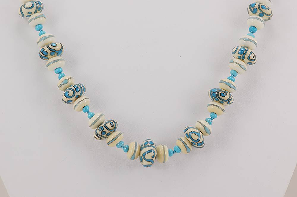 Turquoise and ivory colored glass and stone bead necklace.
