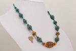 Handmade orange and teal colored glass bead necklace with sterling silver accents.