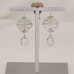 Handmade, solid silver quatrefoil earrings with dangling quartz crystals.