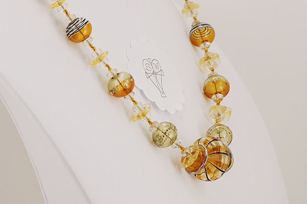 Necklace with quartz crystal and amber colored glass beads.