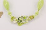 necklace made with lime green and ivory colored glass beads flanked by clear quartz round beads