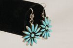 Turquoise and silver flower earrings three quarter view.