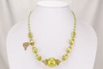 Elegant, one of a kind hand blown green and gold glass bead necklace.