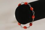 Bracelet handmade with persimmon colored, bamboo coral beads on sterling silver wire links.
