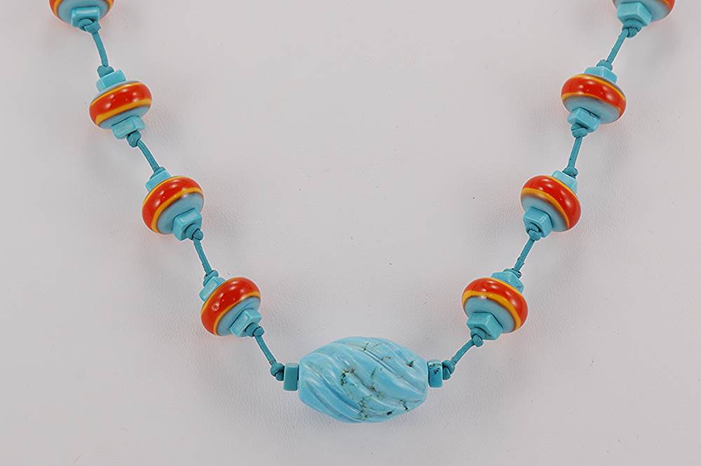 Handmade turquoise necklace with reddish orange glass beads.