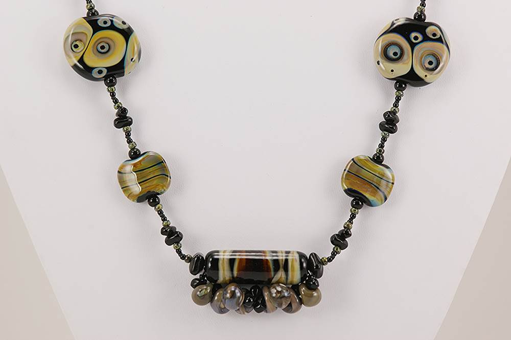 Necklace with black and brown raku and ivory colored glass beads.