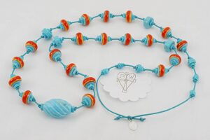 Turquoise necklace with reddish orange and yellow glass beads.