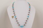 Handmade necklace with turquoise, and reddish orange glass beads.