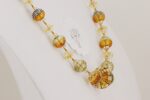 Necklace with quartz crystal and amber colored glass beads.