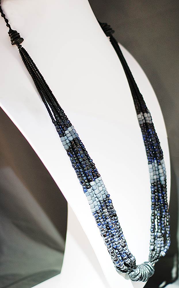 Tribal necklace made of black, gray and blue beads.