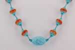 Handmade turquoise necklace with reddish orange glass beads.