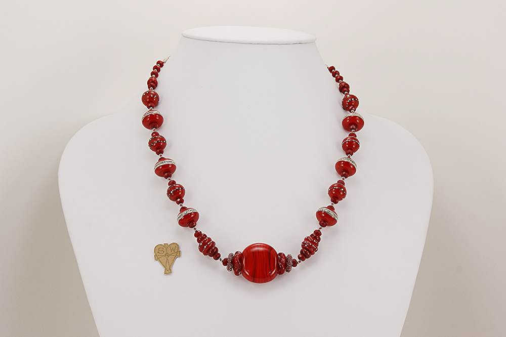 Necklace made of Czech, red, suede glass beads accented by sterling silver.