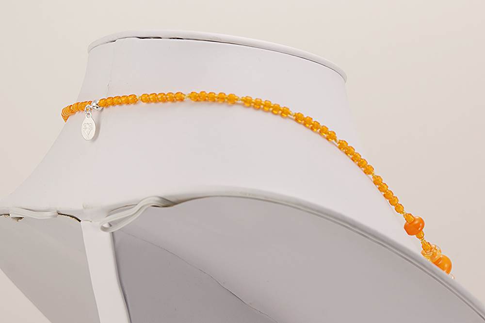 Handmade necklace with bright orange glass beads.