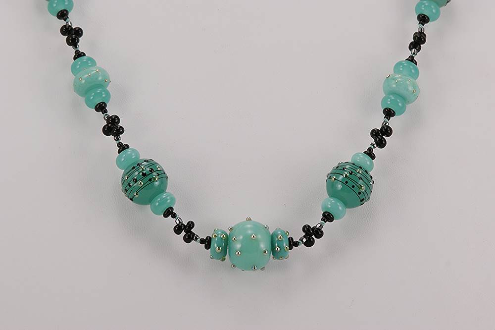 Necklace made of green kryptonite colored glass with sterling silver dotted accents and black spinel beads.