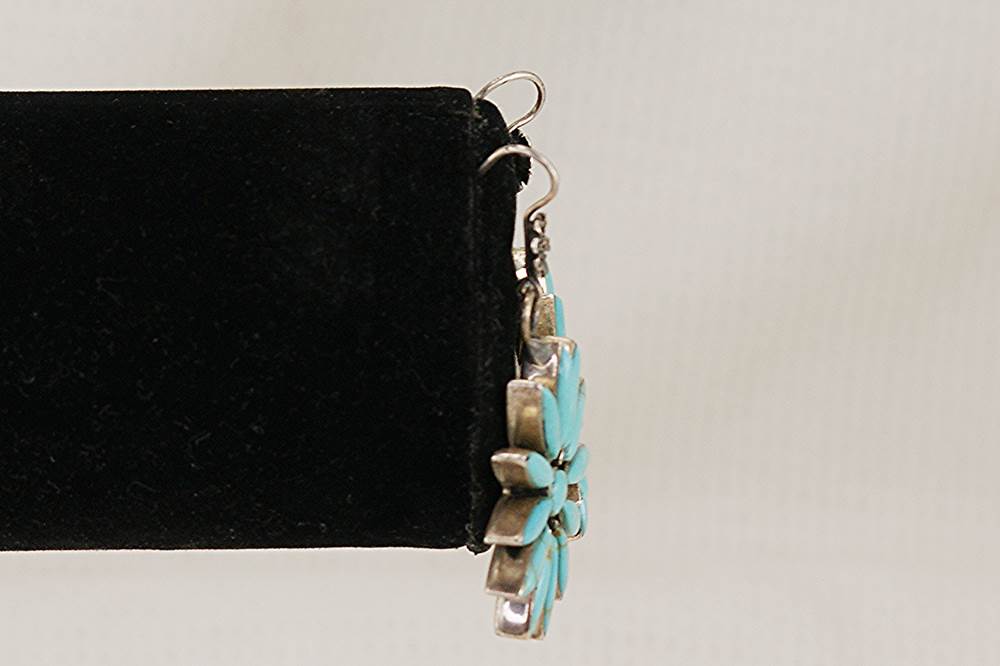 Turquoise and sterling silver flower earring side view.