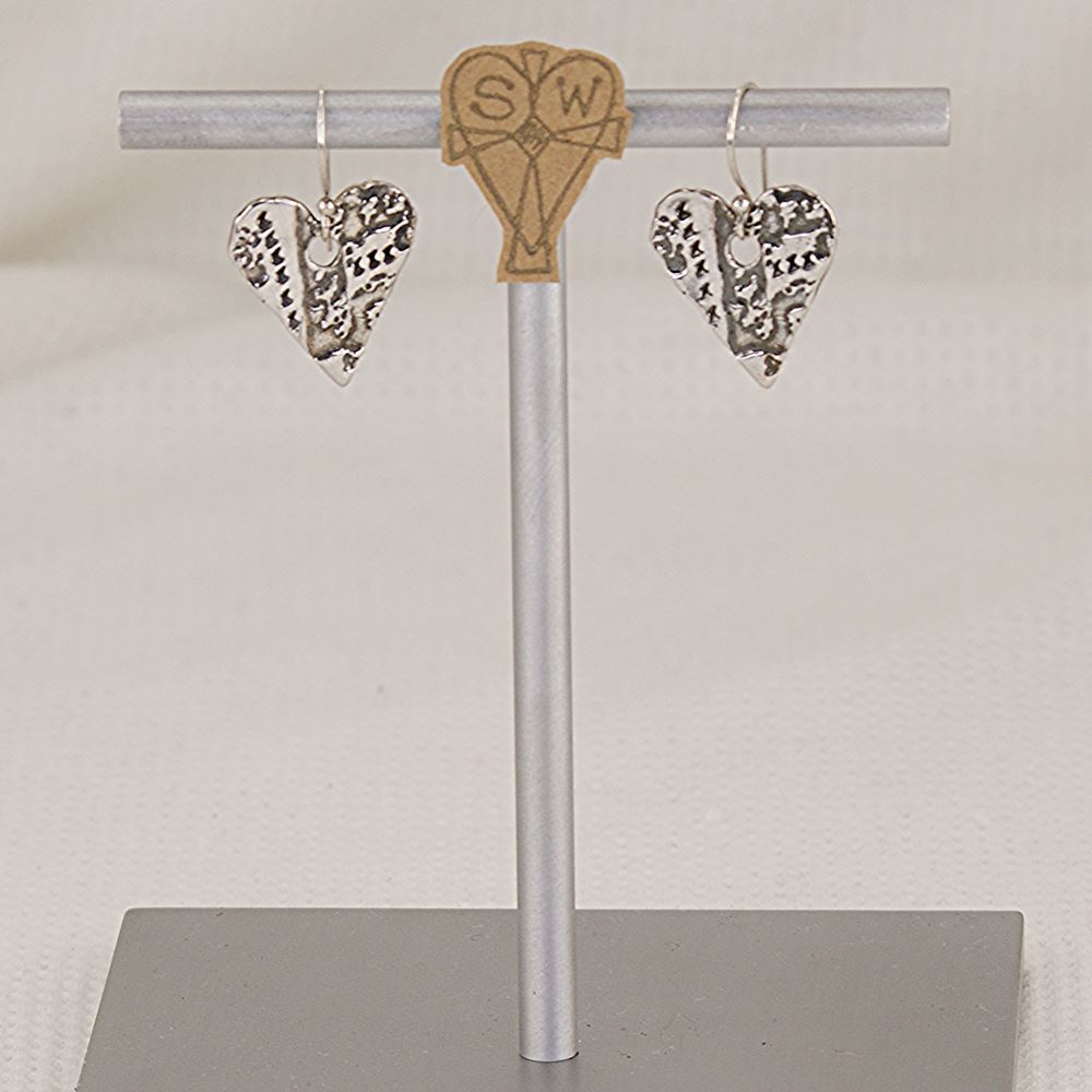Handmade sterling silver heart earrings with artistic imprints.